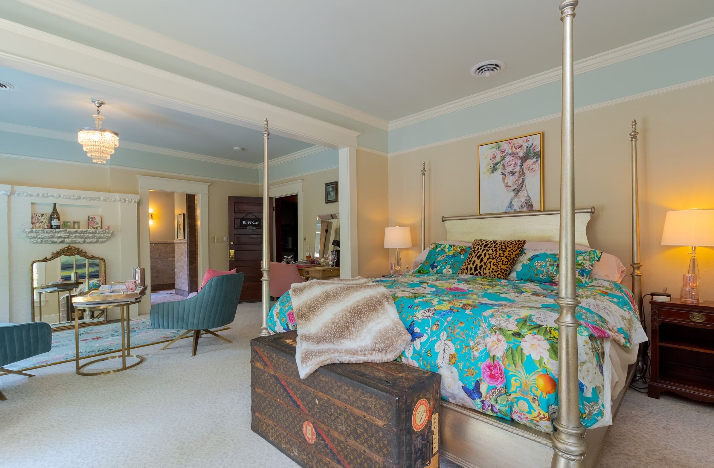 Bedroom with stunning cream & gold four-poster bed and brightly colored bedding.