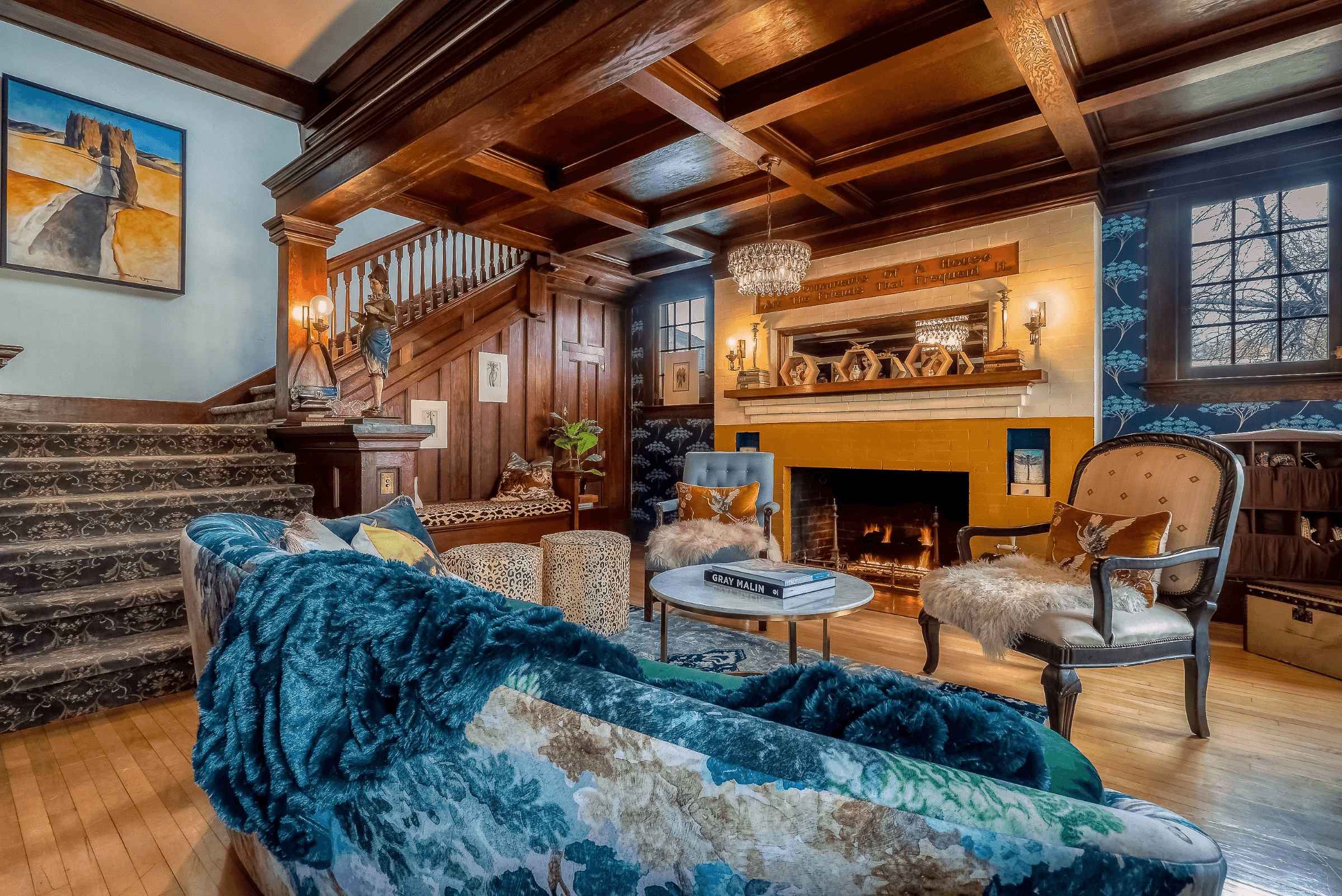 A cozy living room with a fireplace, plush seating, and decorative woodwork.