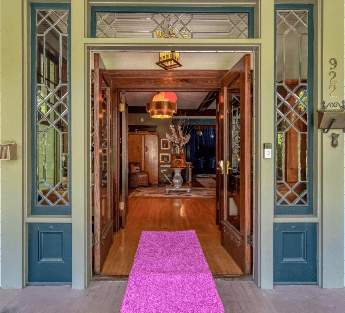 A welcoming entrance with a pink rug leading into a well-decorated living room.