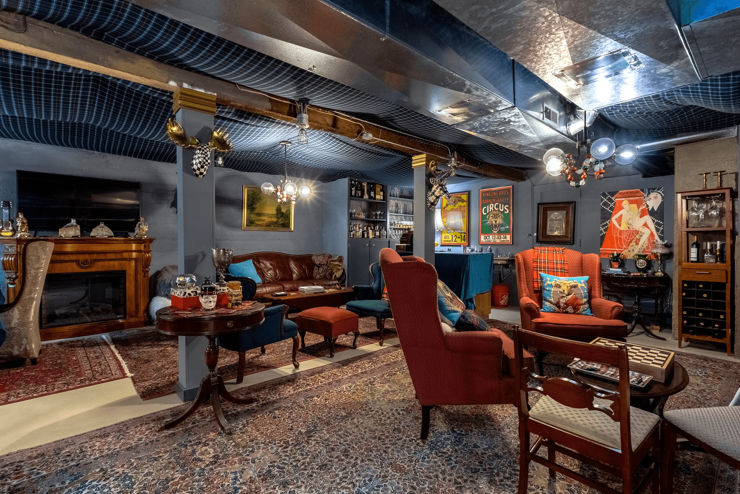 Finished basement lounge featuring a comfy leather sofa and wingback chairs